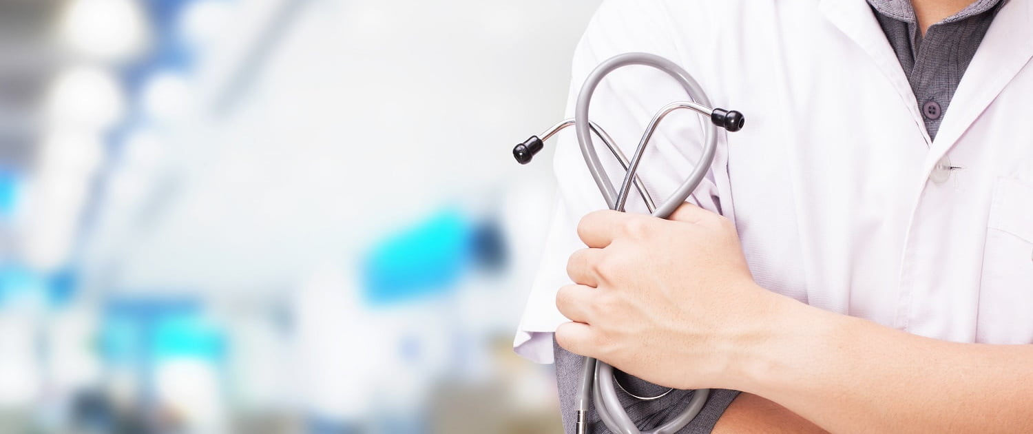 Doctor with a stethoscope in the hands and hospital background